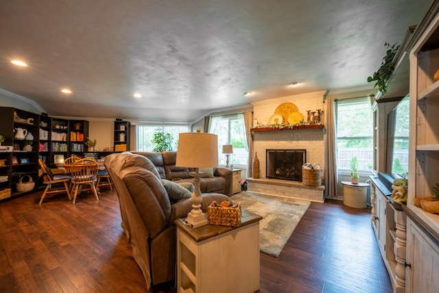 living room featuring a brick fireplace, ornamental molding, and dark hardwood / wood-style flooring