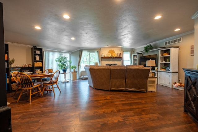 living room with a large fireplace, crown molding, and dark hardwood / wood-style floors