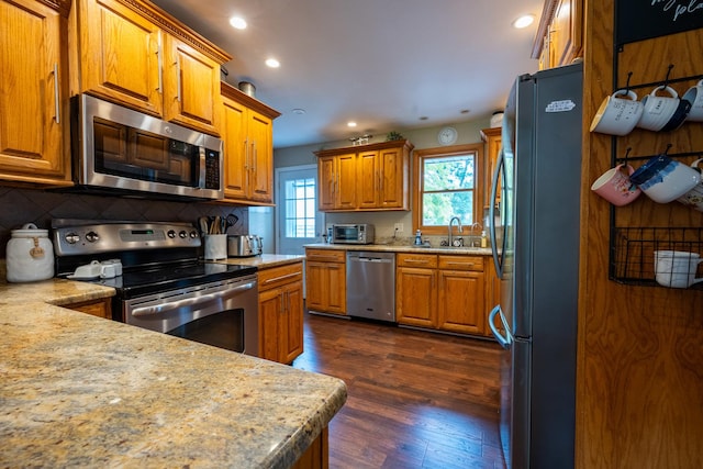 kitchen featuring appliances with stainless steel finishes, dark hardwood / wood-style floors, sink, and decorative backsplash