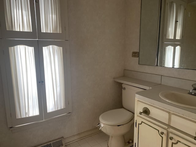 bathroom with toilet, a baseboard heating unit, tile patterned floors, and vanity