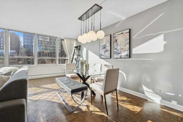 dining room featuring parquet flooring and a baseboard heating unit