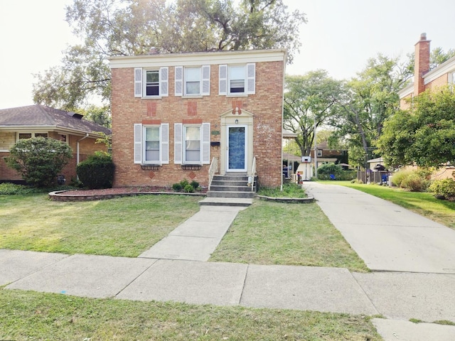 view of front facade with a front yard and brick siding