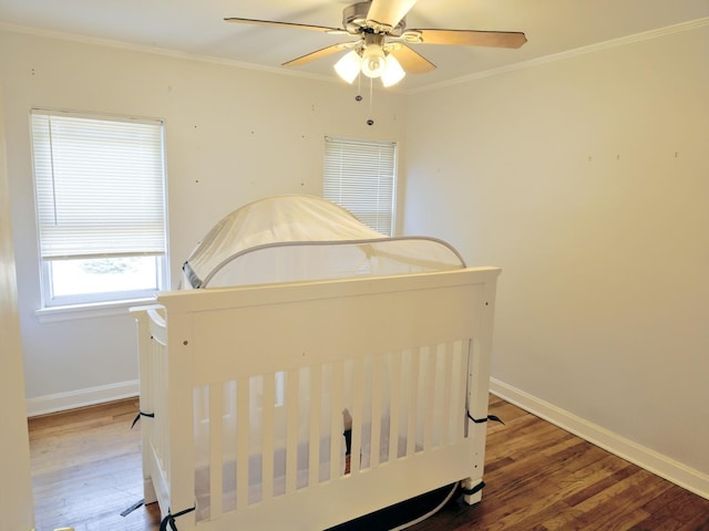 bedroom featuring ornamental molding, baseboards, and wood finished floors