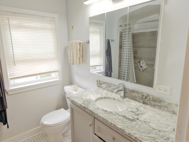 bathroom with curtained shower, vanity, toilet, and baseboards