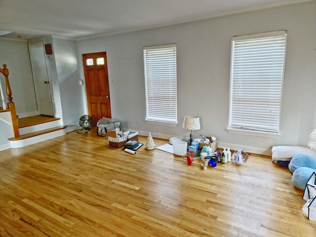 foyer with crown molding, stairs, baseboards, and wood finished floors