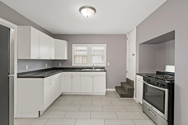 kitchen featuring white cabinets, stainless steel gas range oven, and sink