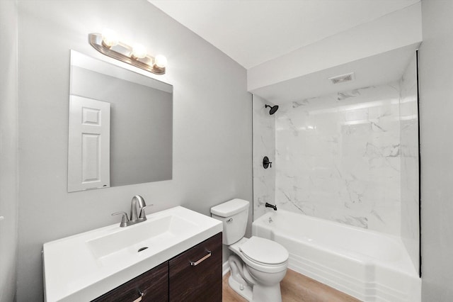 full bathroom with wood-type flooring, vanity, tiled shower / bath combo, and toilet