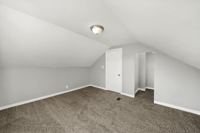 bonus room featuring lofted ceiling and dark carpet