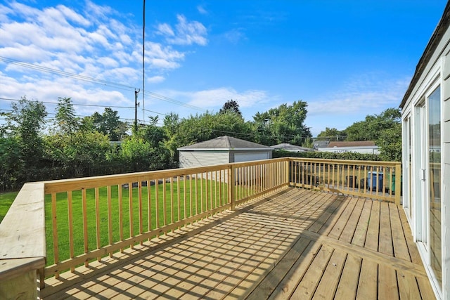 wooden terrace with a lawn, an outbuilding, and a garage