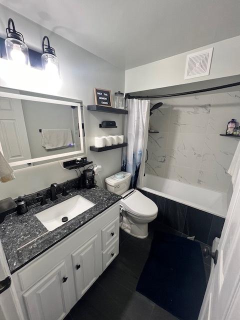 full bathroom with toilet, vanity, tile patterned floors, and shower / bath combo with shower curtain