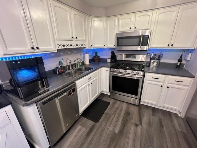 kitchen featuring sink, white cabinetry, dark wood-type flooring, and appliances with stainless steel finishes