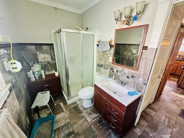 bathroom featuring toilet, tile walls, a shower with door, ornamental molding, and vanity