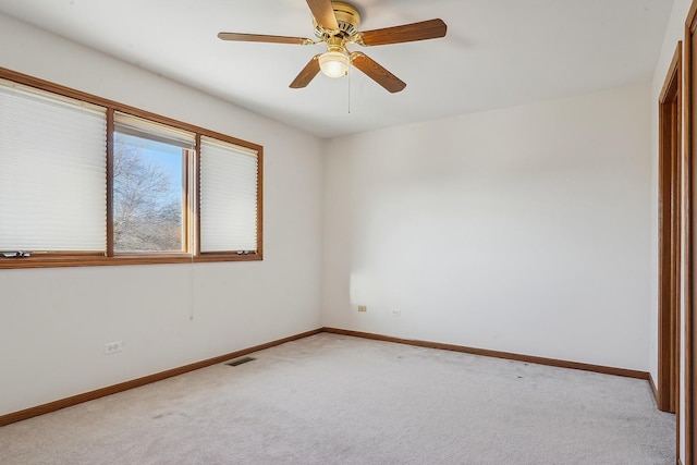 carpeted spare room with ceiling fan