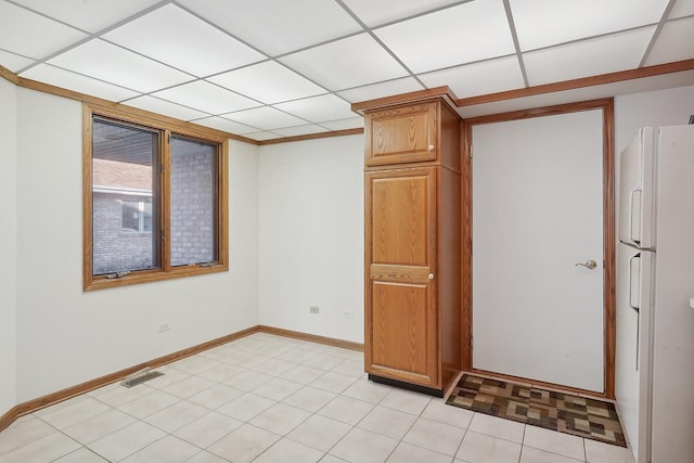 tiled empty room with a paneled ceiling