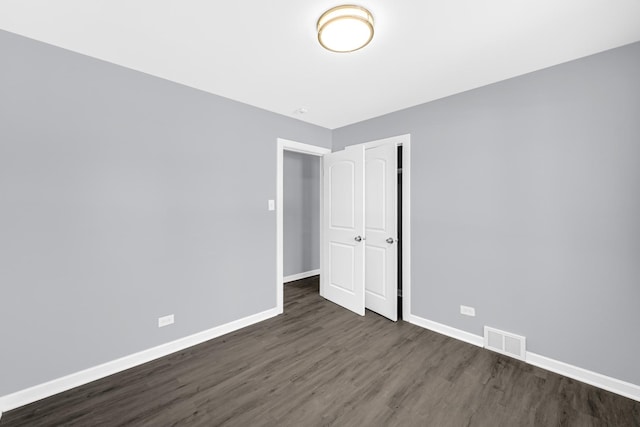 unfurnished bedroom featuring dark hardwood / wood-style floors