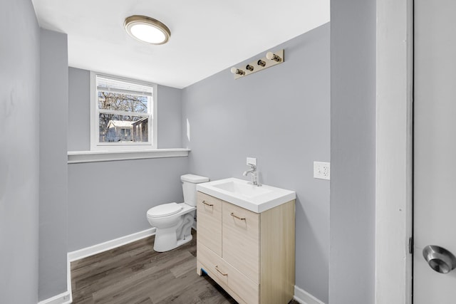 bathroom featuring toilet, wood-type flooring, and vanity