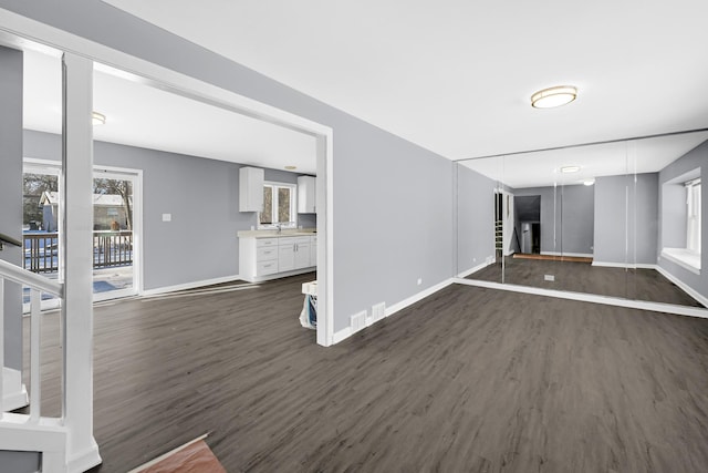 unfurnished living room with sink and dark hardwood / wood-style floors