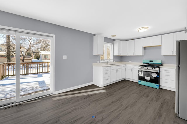 kitchen featuring sink, stainless steel appliances, a healthy amount of sunlight, and white cabinetry