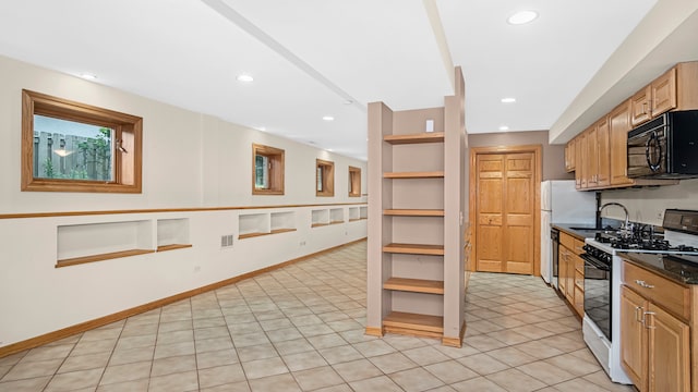 kitchen featuring sink, white refrigerator, gas range oven, built in shelves, and light brown cabinets