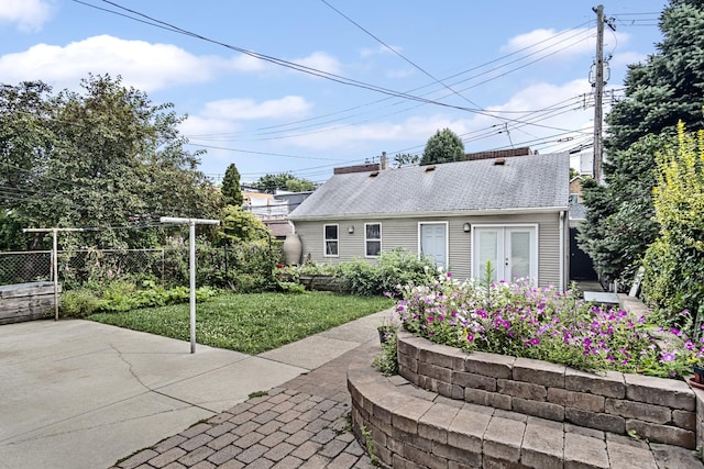 rear view of house with a lawn and a patio area