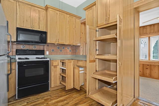 kitchen featuring range with gas cooktop, light brown cabinets, wooden walls, light hardwood / wood-style floors, and decorative backsplash