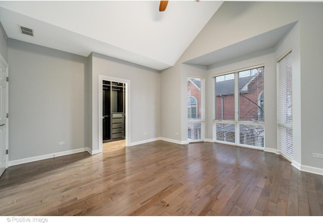 unfurnished room with ceiling fan, high vaulted ceiling, and wood-type flooring