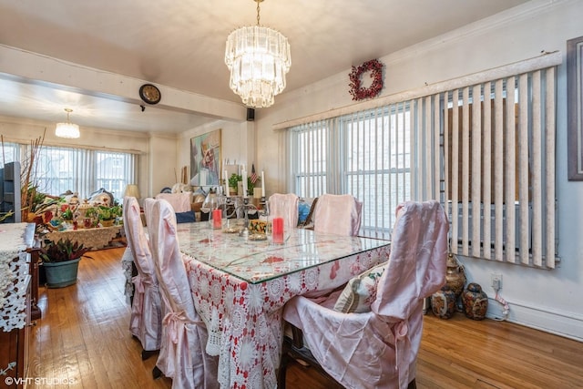 dining area with an inviting chandelier, crown molding, and hardwood / wood-style floors