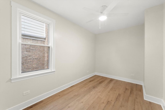 empty room with ceiling fan, light wood-type flooring, and a wealth of natural light