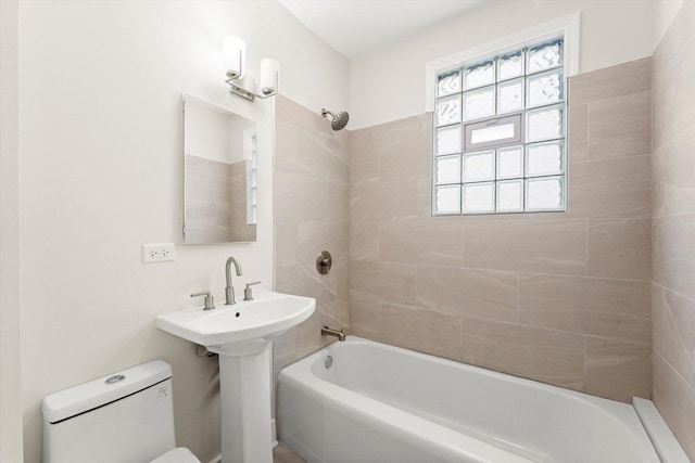 full bathroom featuring toilet, sink, and tiled shower / bath combo