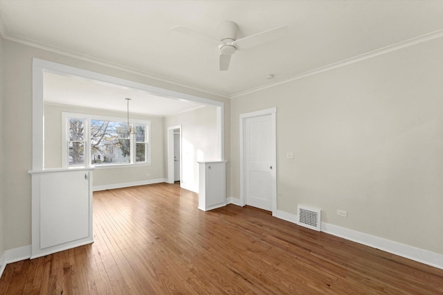 spare room featuring crown molding, ceiling fan with notable chandelier, and wood-type flooring