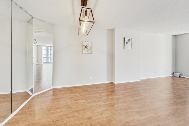 unfurnished room featuring a textured ceiling and hardwood / wood-style flooring