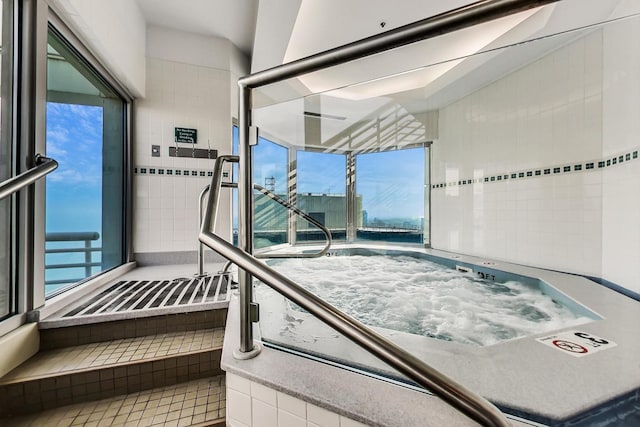 interior space featuring a water view and an indoor in ground hot tub