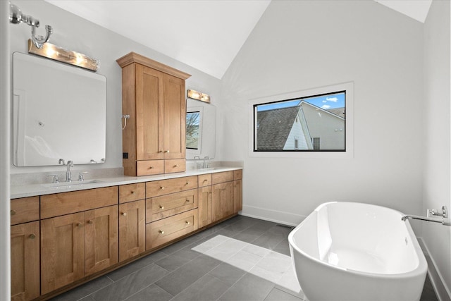 bathroom featuring lofted ceiling, tile patterned flooring, vanity, and a bathing tub