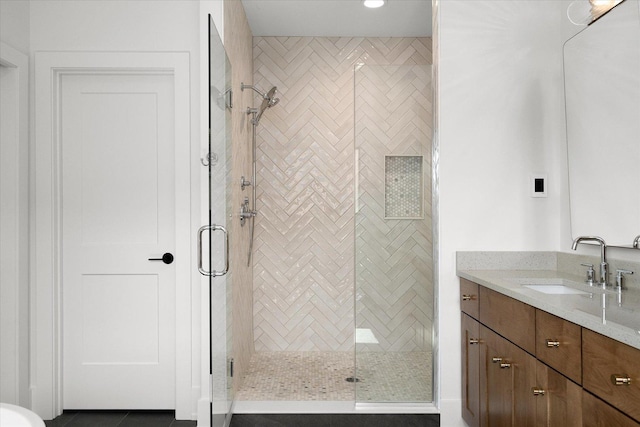 bathroom with a shower with door, tile patterned floors, and vanity