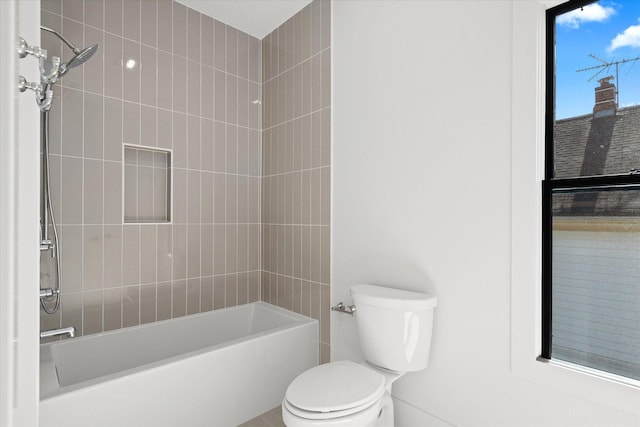 bathroom with toilet and tiled shower / bath