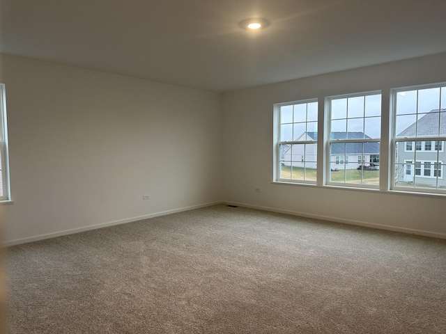 empty room featuring plenty of natural light and carpet flooring