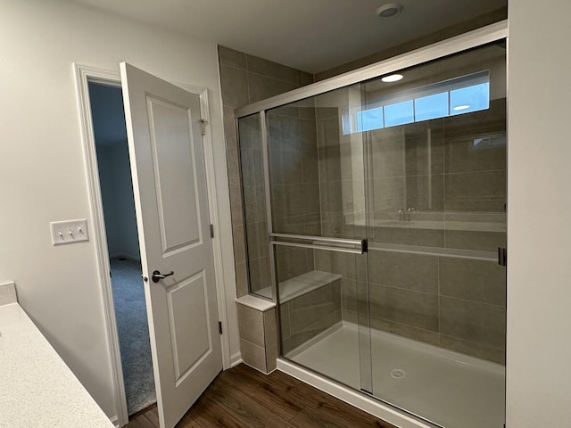 bathroom with vanity, hardwood / wood-style floors, and a shower with door