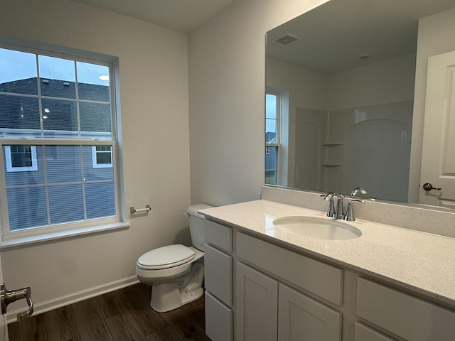 bathroom featuring walk in shower, vanity, wood-type flooring, and toilet