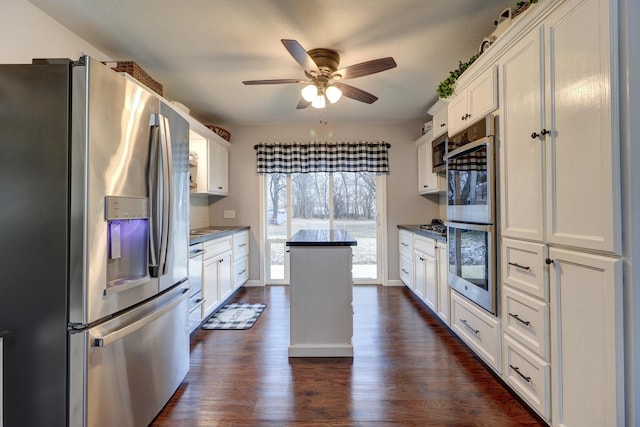 kitchen with ceiling fan, stainless steel appliances, dark hardwood / wood-style flooring, and white cabinets