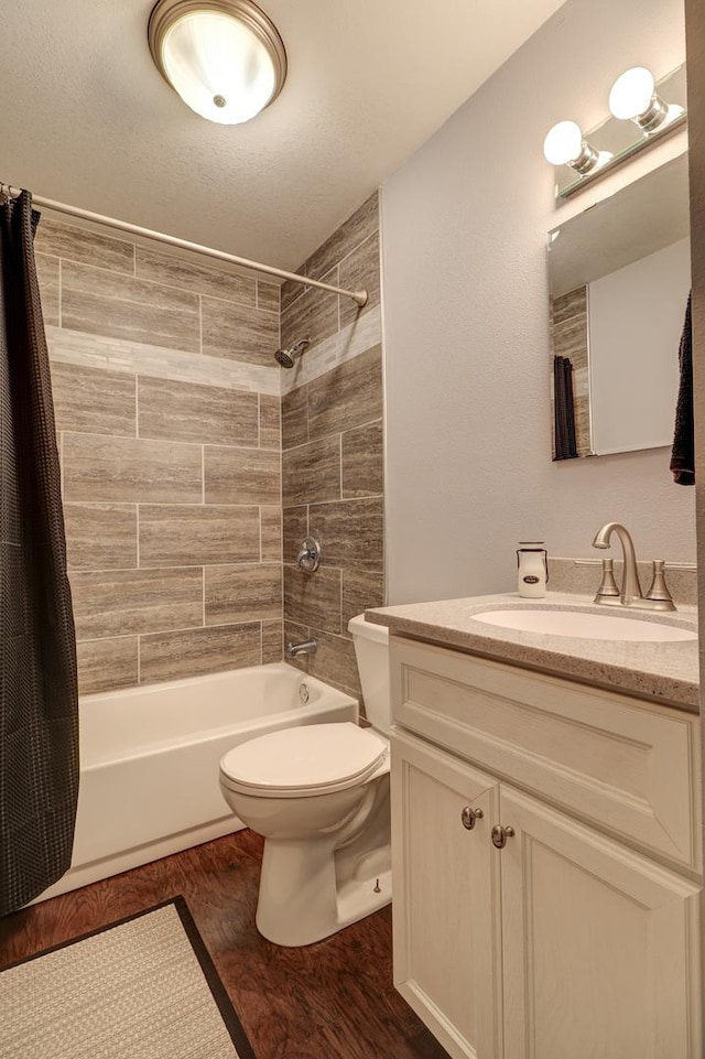 full bathroom with hardwood / wood-style floors, toilet, vanity, and shower / tub combo with curtain