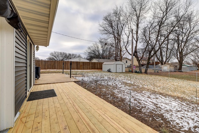 snow covered deck with a shed