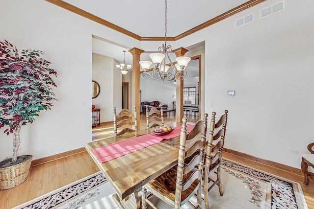 dining area with ornamental molding, wood-type flooring, and a notable chandelier