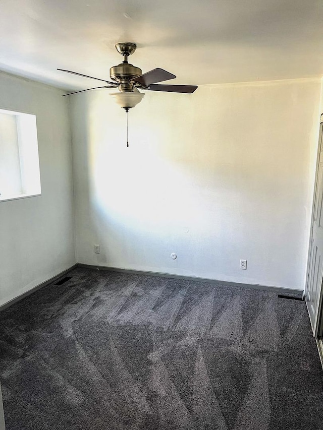 spare room with ceiling fan and carpet