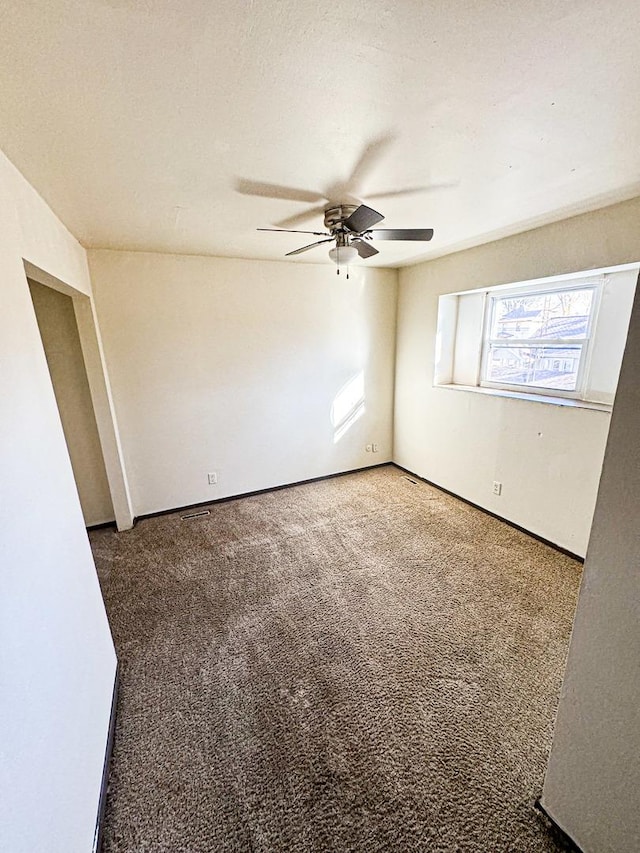 spare room featuring ceiling fan and carpet