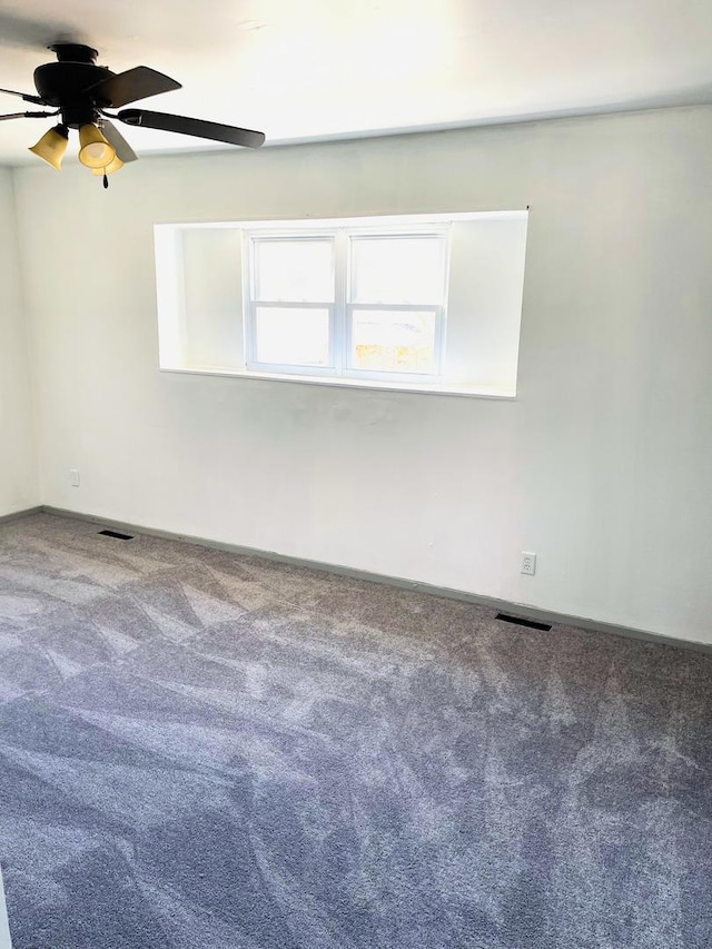 carpeted spare room with ceiling fan