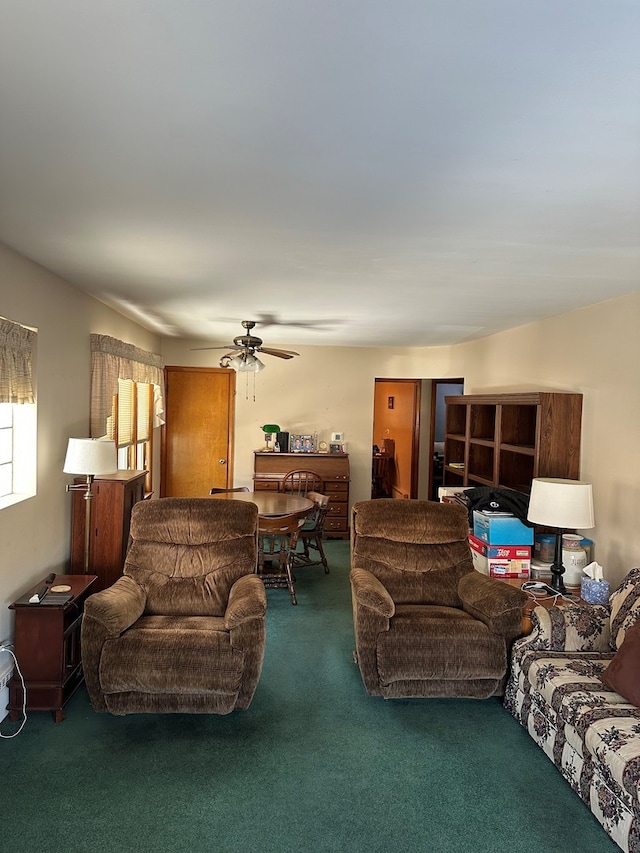 living room featuring dark colored carpet and ceiling fan