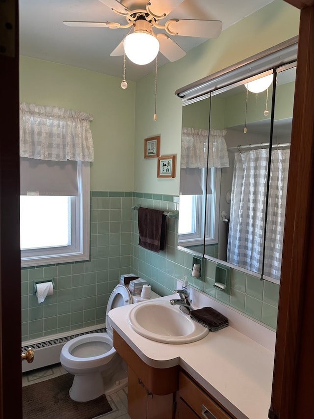 bathroom featuring tile patterned flooring, toilet, vanity, tile walls, and ceiling fan