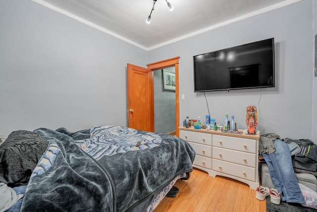 bedroom with hardwood / wood-style flooring and crown molding