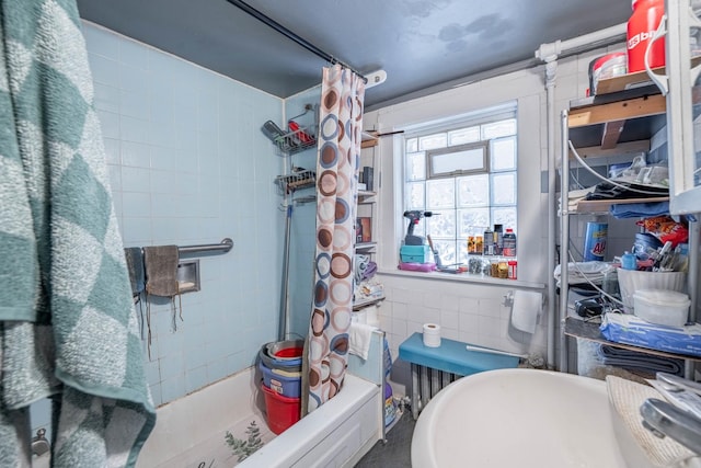 bathroom with sink, tile walls, and shower / bath combo