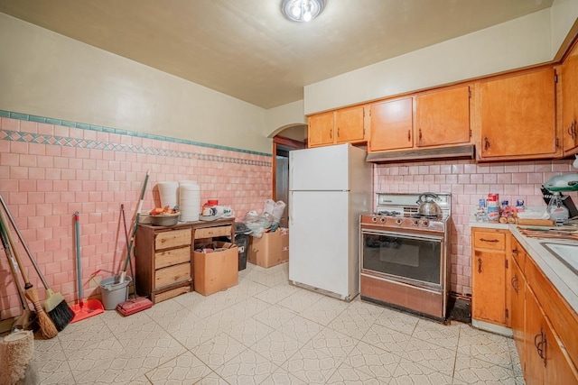 kitchen with gas range and white fridge